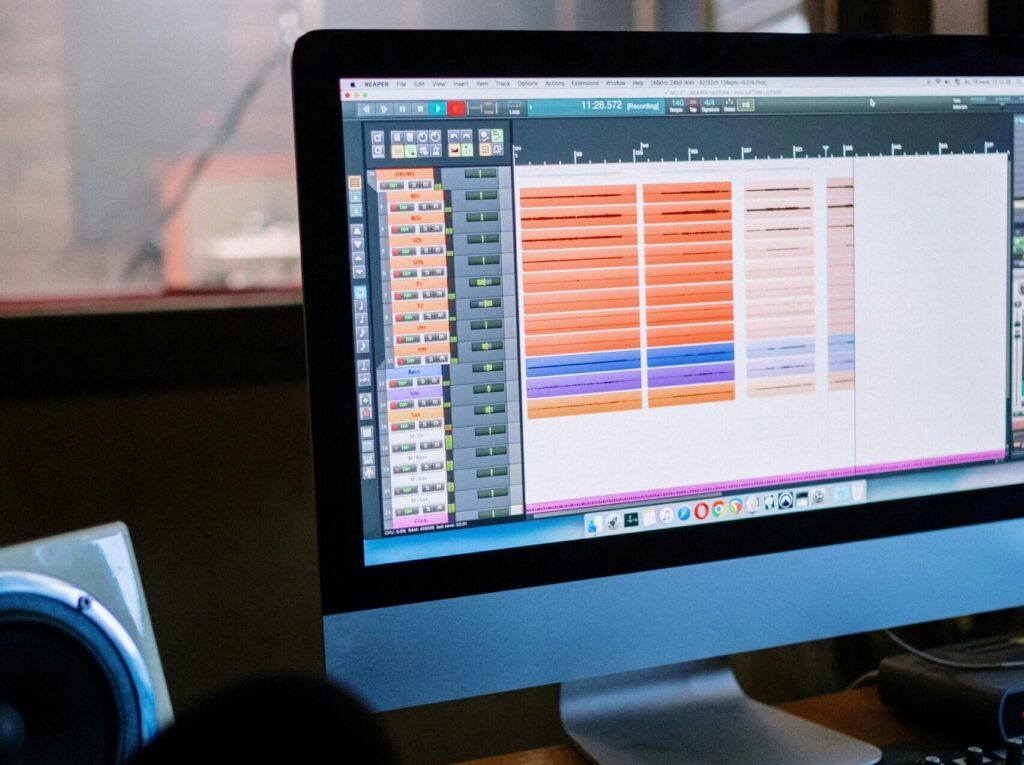 Modern recording studio with computer and mixing console, inside view.